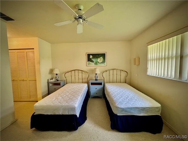 carpeted bedroom with ceiling fan and a closet