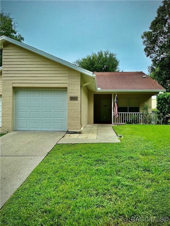 ranch-style home featuring a porch, a garage, and a front lawn