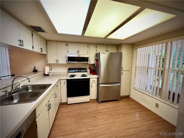 kitchen featuring sink, stainless steel appliances, extractor fan, white cabinets, and light wood-type flooring