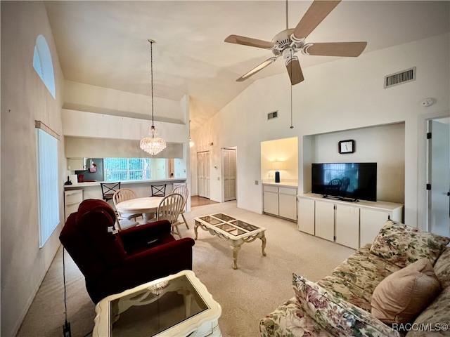 living room with ceiling fan with notable chandelier and high vaulted ceiling