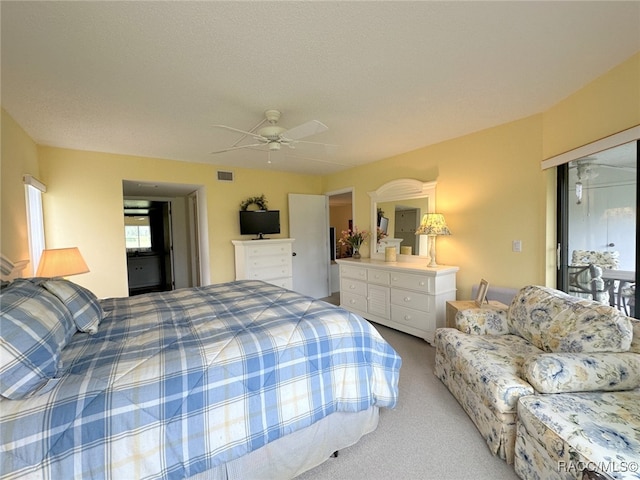 carpeted bedroom with ceiling fan and a textured ceiling