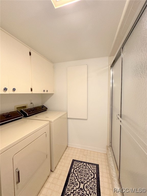 washroom with cabinets and washer and clothes dryer