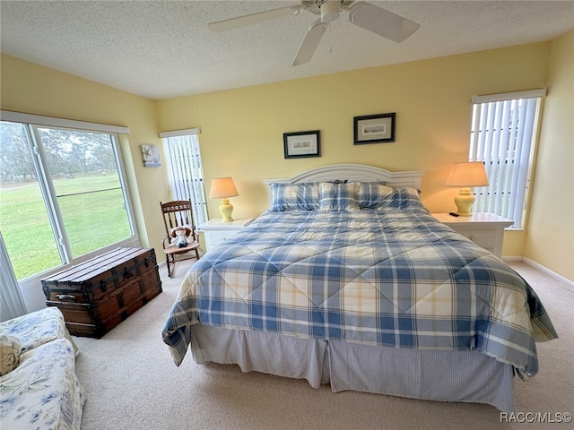 carpeted bedroom featuring a textured ceiling and ceiling fan