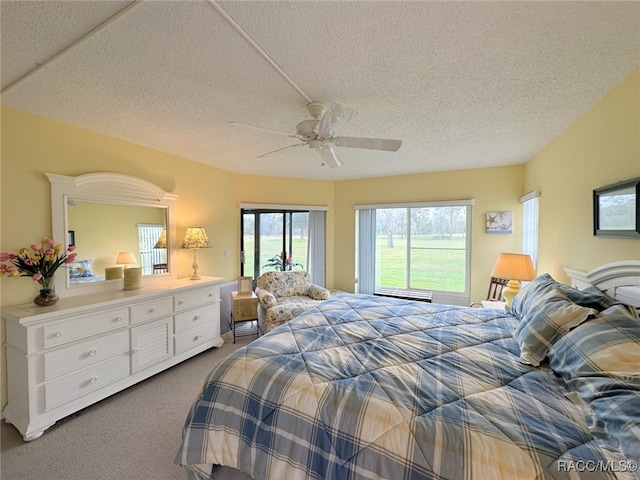 carpeted bedroom featuring a textured ceiling and ceiling fan