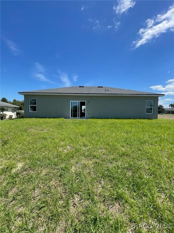 back of house with a lawn