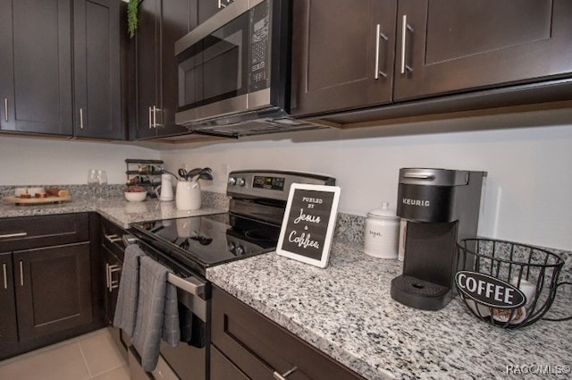 kitchen featuring dark brown cabinets, light tile patterned flooring, and appliances with stainless steel finishes