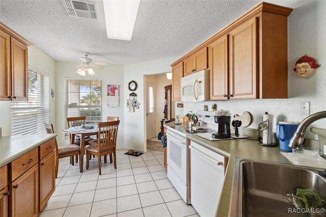 kitchen with a textured ceiling, white appliances, ceiling fan, sink, and light tile patterned flooring