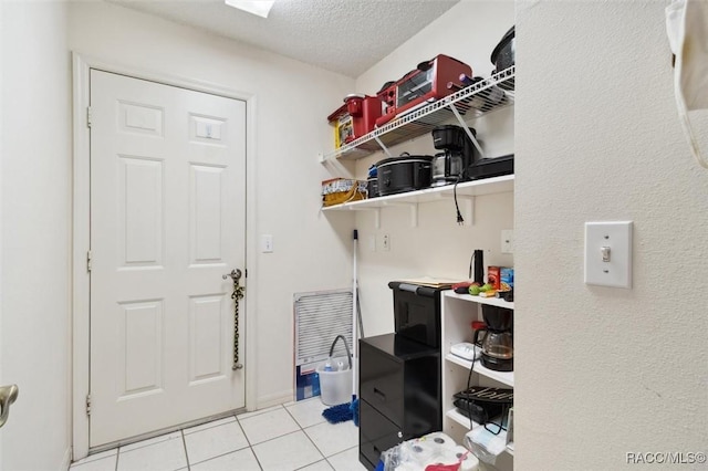 washroom featuring light tile patterned floors and a textured ceiling