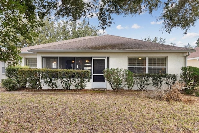 single story home featuring a front yard and a sunroom