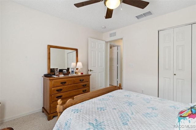 carpeted bedroom with a textured ceiling, a closet, and ceiling fan