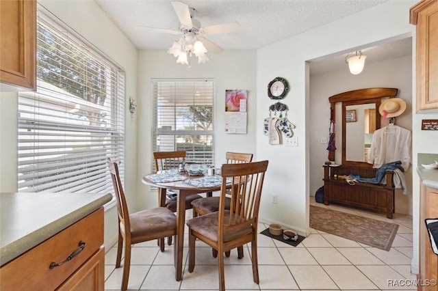 tiled dining room with ceiling fan and a textured ceiling