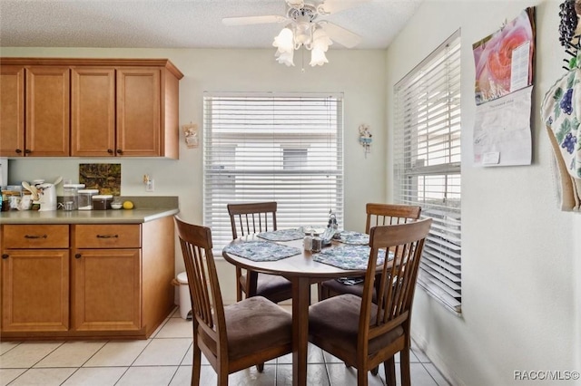 dining room featuring ceiling fan, light tile patterned flooring, and a textured ceiling