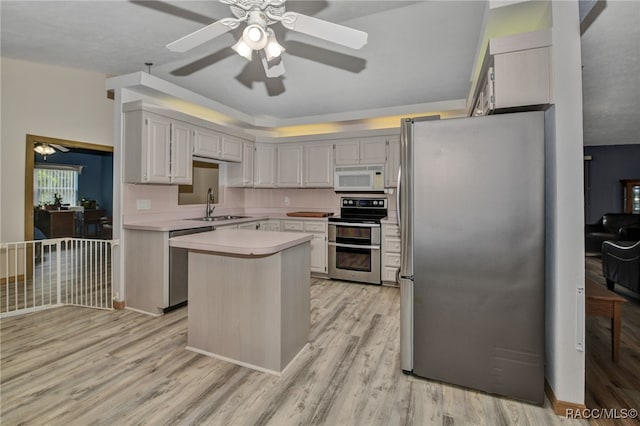 kitchen featuring sink, light hardwood / wood-style flooring, a kitchen island, and appliances with stainless steel finishes