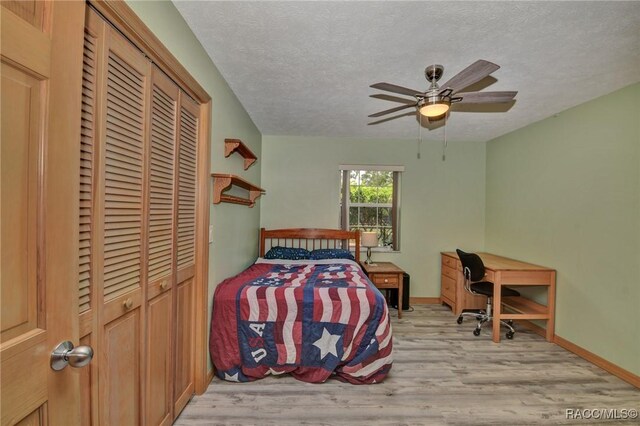 3670 W Cogwood Cir, Beverly Hills, FL 34465 - bedroom with light wood finished floors, a textured ceiling, a closet, baseboards, and ceiling fan