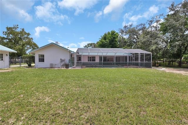 back of property featuring a lanai and a lawn