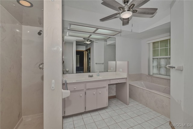 bathroom featuring tile patterned flooring, a relaxing tiled tub, and vanity