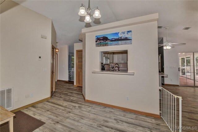 3670 W Cogwood Cir, Beverly Hills, FL 34465 - unfurnished dining area with wood finished floors, a chandelier, baseboards, high vaulted ceiling, and a ceiling fan