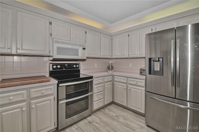 3670 W Cogwood Cir, Beverly Hills, FL 34465 - kitchen with stainless steel appliances, light countertops, tasteful backsplash, and light wood finished floors