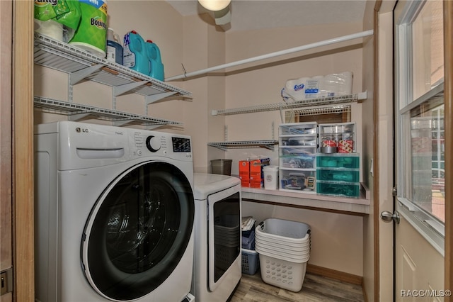 washroom with light hardwood / wood-style flooring and washer and clothes dryer