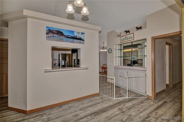 3670 W Cogwood Cir, Beverly Hills, FL 34465 - corridor with a chandelier, wood finished floors, and baseboards