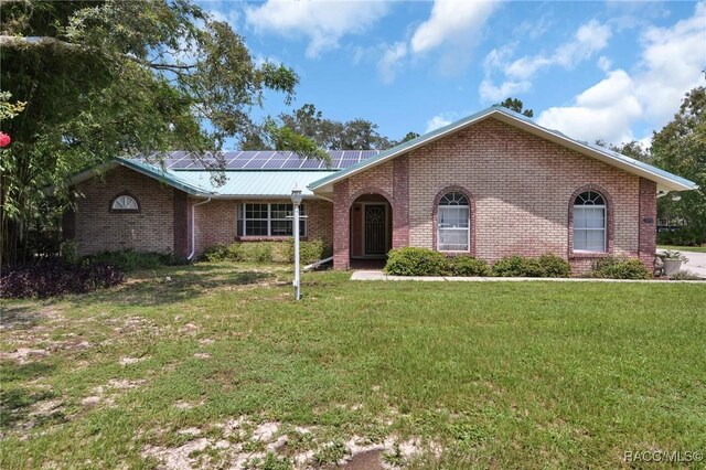 3670 W Cogwood Cir, Beverly Hills, FL 34465 - ranch-style home featuring solar panels, brick siding, a front yard, and metal roof