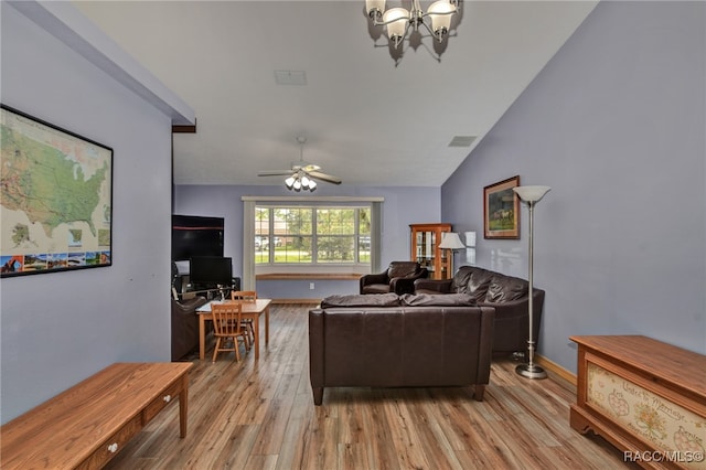 living room with ceiling fan with notable chandelier, light hardwood / wood-style flooring, and vaulted ceiling