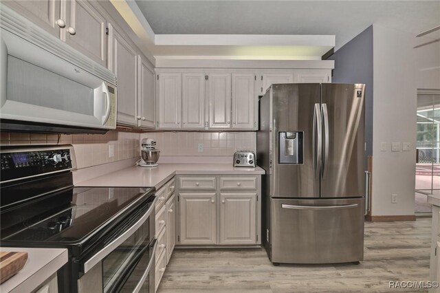 3670 W Cogwood Cir, Beverly Hills, FL 34465 - kitchen with stainless steel appliances, light countertops, light wood finished floors, tasteful backsplash, and baseboards