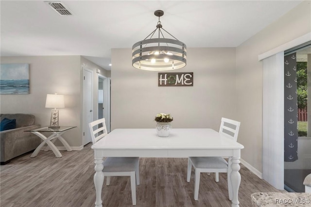 70 W Casurina Pl, Beverly Hills, FL 34465 - dining room with wood finished floors, baseboards, and a chandelier