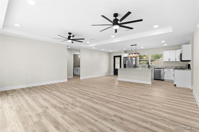 2828 E Celina St, Inverness, FL 34453 - unfurnished living room featuring a tray ceiling, recessed lighting, light wood finished floors, and a ceiling fan