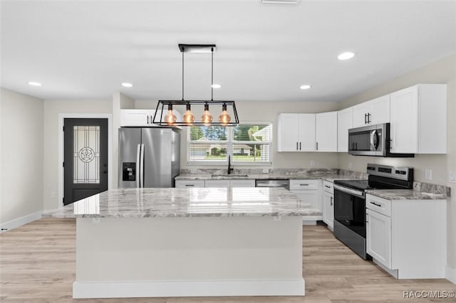 2828 E Celina St, Inverness, FL 34453 - kitchen featuring stainless steel appliances, a center island, light stone countertops, white cabinets, and decorative light fixtures