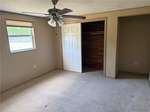 438 S Camillia Ave, Crystal River, FL 34429 - unfurnished bedroom featuring carpet floors, a closet, a ceiling fan, and wood walls