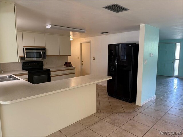 438 S Camillia Ave, Crystal River, FL 34429 - kitchen featuring black appliances, light tile patterned flooring, light countertops, a peninsula, and white cabinetry