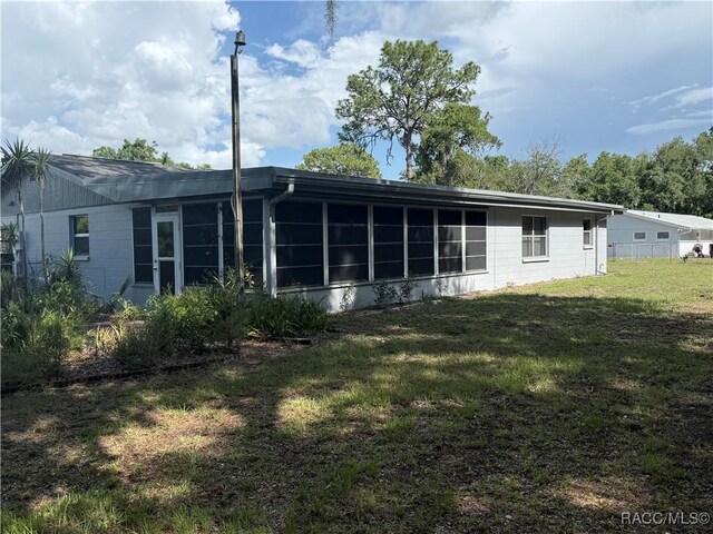 438 S Camillia Ave, Crystal River, FL 34429 - rear view of house with a lawn and a sunroom