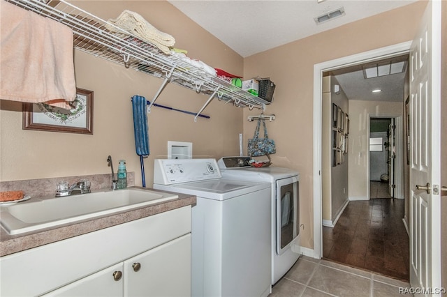 laundry area with washer and dryer, light hardwood / wood-style floors, and sink