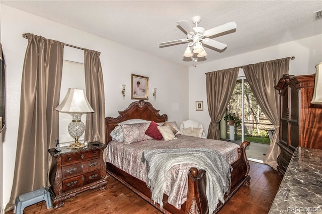 bedroom with access to exterior, a textured ceiling, dark hardwood / wood-style floors, and ceiling fan