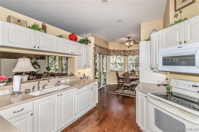 kitchen with white appliances, white cabinetry, ceiling fan, and sink