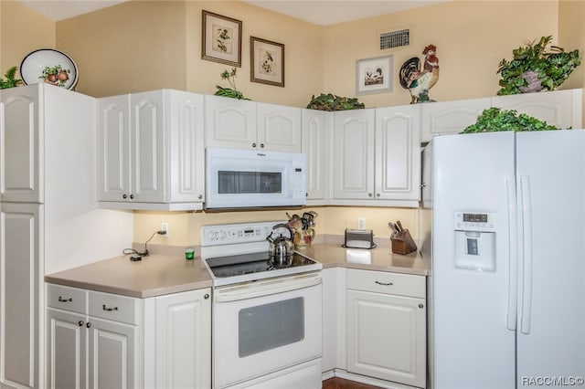 kitchen featuring white cabinets and white appliances