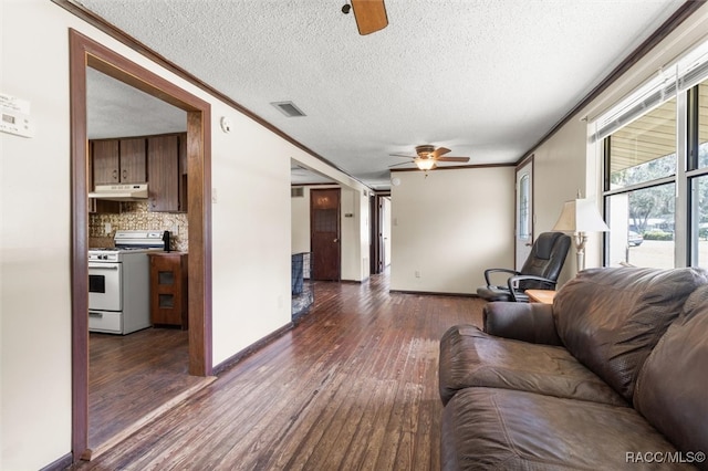 living room featuring ceiling fan, crown molding, dark wood-type flooring, and a textured ceiling