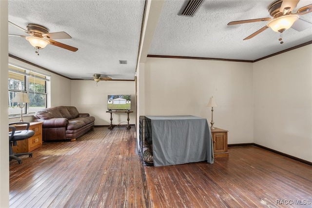 living room featuring dark hardwood / wood-style floors, ornamental molding, and a textured ceiling