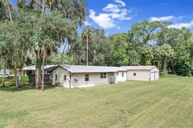 back of property with an outbuilding, a garage, and a lawn