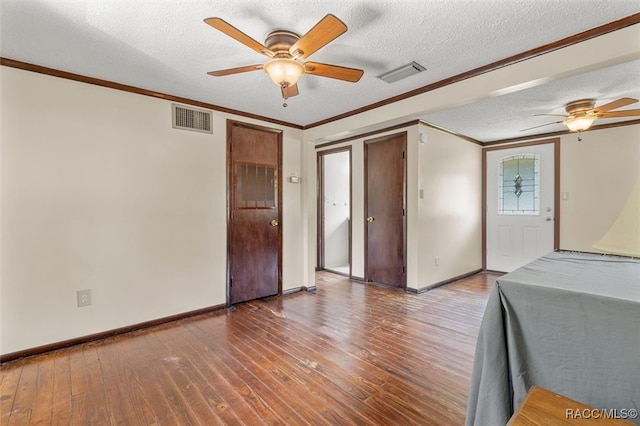 interior space featuring wood-type flooring, a textured ceiling, ceiling fan, and crown molding