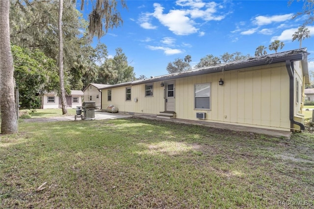 back of property with a lawn and a patio area