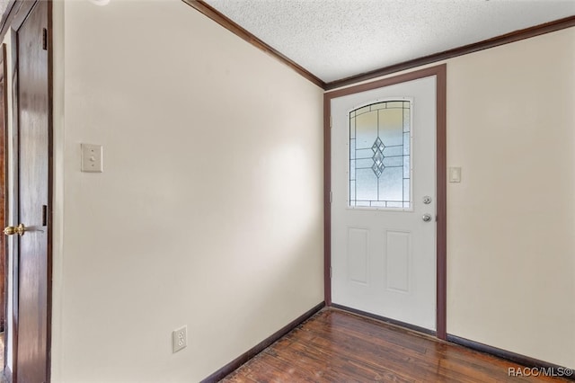 entrance foyer featuring dark hardwood / wood-style flooring, a textured ceiling, and ornamental molding