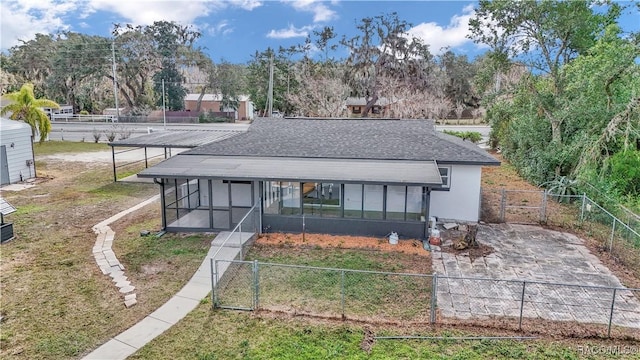 9019 E Gulf To Lake Hwy, Inverness, FL 34450 - view of front of home featuring a sunroom, a shingled roof, a fenced backyard, and a gate