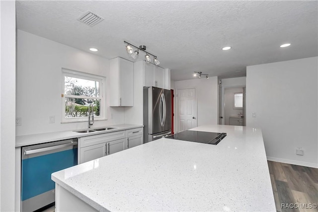9019 E Gulf To Lake Hwy, Inverness, FL 34450 - kitchen featuring dishwashing machine, freestanding refrigerator, a center island, white cabinets, and a textured ceiling