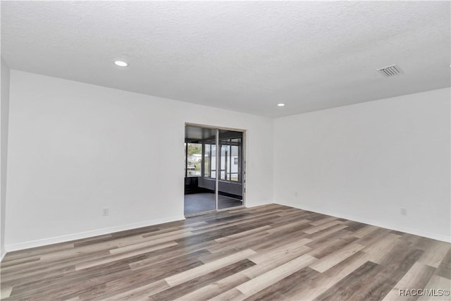 9019 E Gulf To Lake Hwy, Inverness, FL 34450 - empty room featuring wood finished floors, a textured ceiling, and recessed lighting