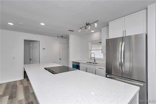 9019 E Gulf To Lake Hwy, Inverness, FL 34450 - kitchen featuring stainless steel appliances, white cabinets, a center island, wood finished floors, and a textured ceiling