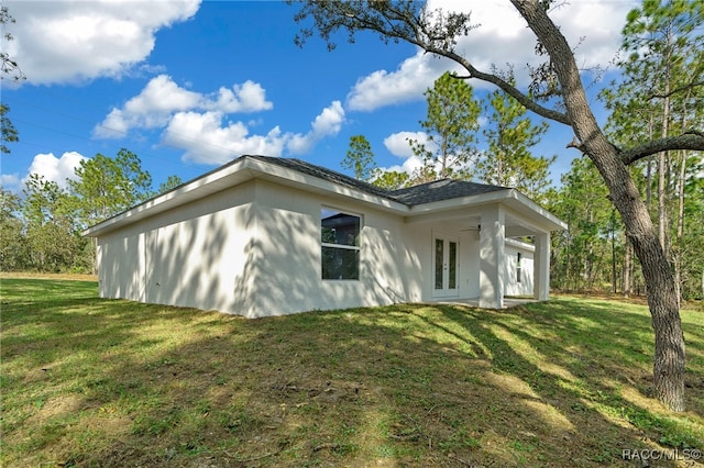 view of side of property featuring french doors and a yard