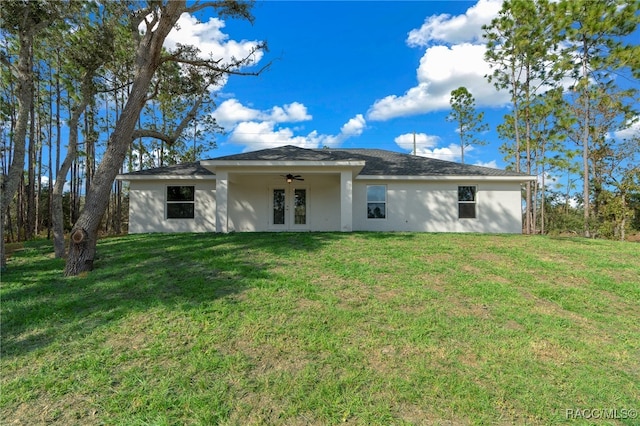 back of house with a lawn, ceiling fan, and french doors