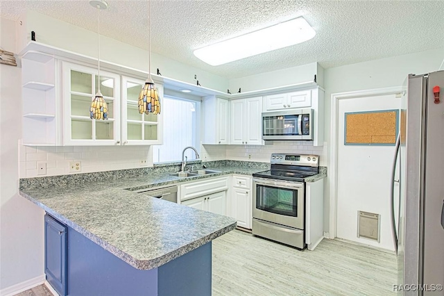 6176 W Pinedale Cir, Crystal River, FL 34429 - kitchen with stainless steel appliances, white cabinetry, a peninsula, decorative backsplash, and a textured ceiling
